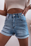 Front view of high-waist denim shorts with sparkling rhinestone detailing, featuring a classic five-pocket design, rolled cuffs, and a flattering fit for a trendy, elevated look.







