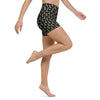 Model in motion wearing black high-waisted yoga shorts with neon rose print.