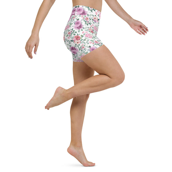 Model in motion wearing white yoga shorts with elegant fall floral design.
