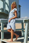 Side-angle photo of a tiered midi dress in soft azure blue, emphasizing the cap sleeves and airy silhouette that moves gracefully with every step.