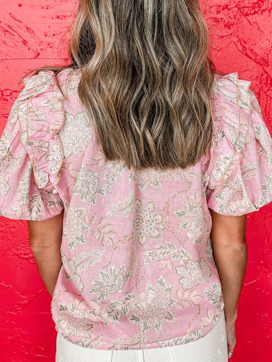 Back view of the pink puff sleeve floral blouse on model, featuring a relaxed cut and soft fabric drape.