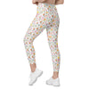 Model walking in high waisted spring floral leggings with bees and butterflies. Women's compression leggings with pockets for yoga, walks, or errands.

