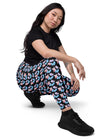 Woman sitting in Black Butterfly Dreams High-Waisted Leggings with Pockets. Featuring a chic butterfly print, high-waisted fit, and functional pockets, ideal for both comfort and style.