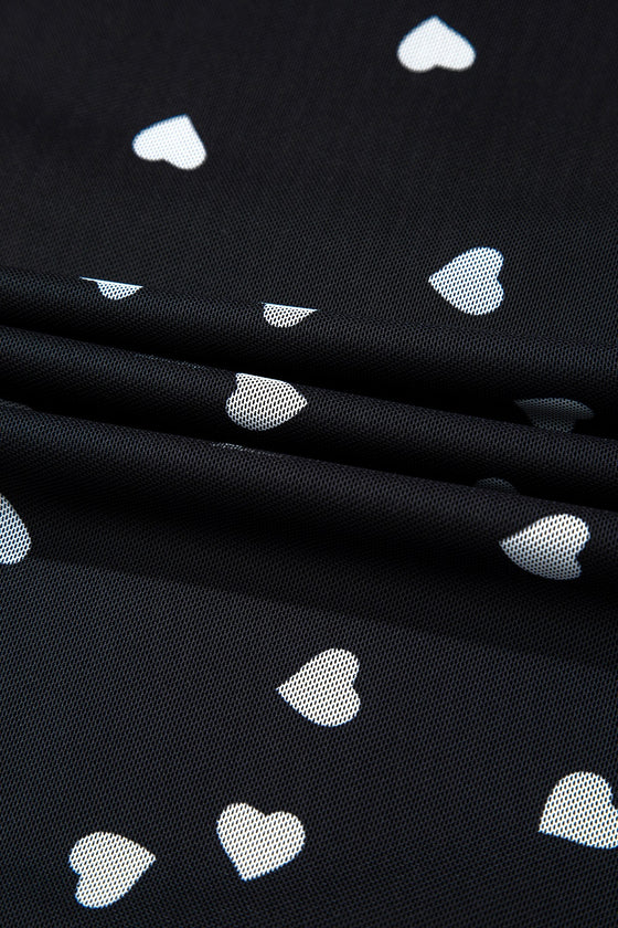 Up-close fabric image showing the lightweight sheer mesh, charming heart design, and air-light construction for breathable, stylish layering.

