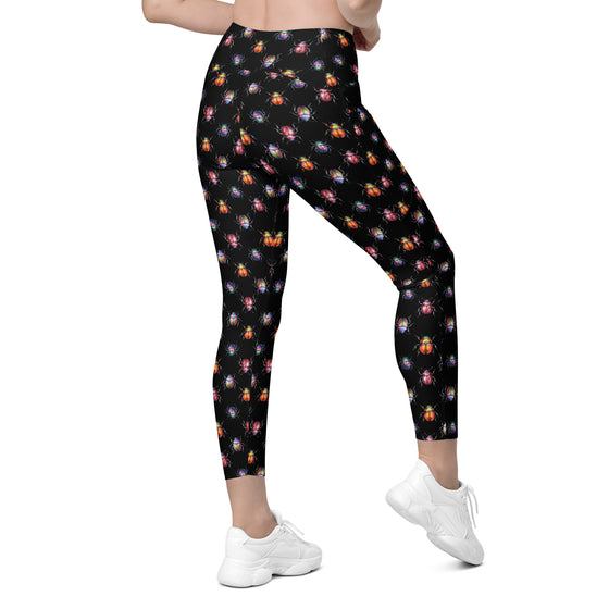 Back view of black leggings with detailed beetle bug print. High waist gym leggings with pockets for women, perfect for workouts or casual wear.
