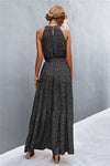Back full view of black printed maxi dress with relaxed drape—classic sleeveless cut with lightweight feel for warm-weather wear.