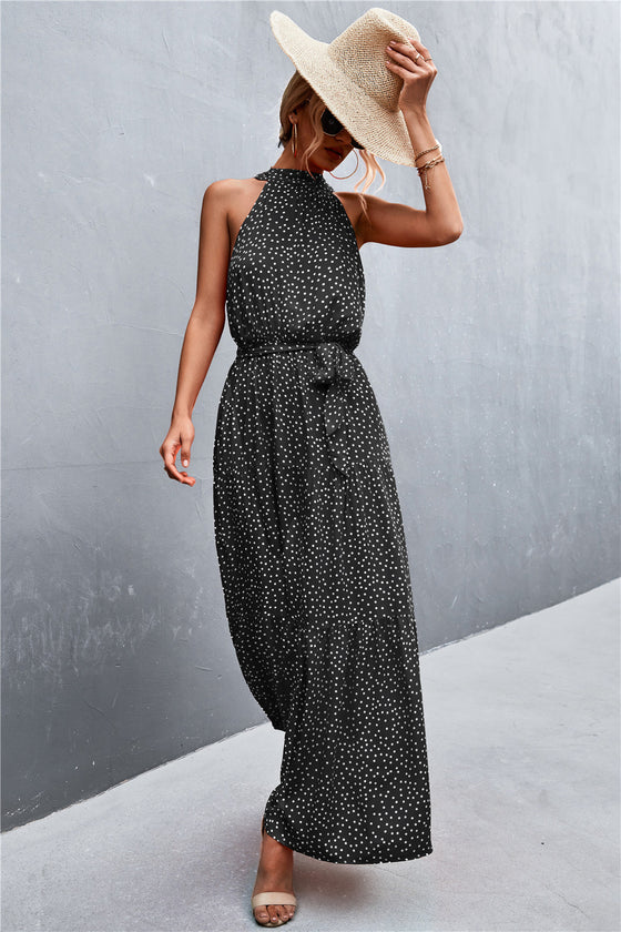  Sleeveless black maxi dress with printed design and waist tie—minimalist and elegant piece suitable for versatile summer styling.