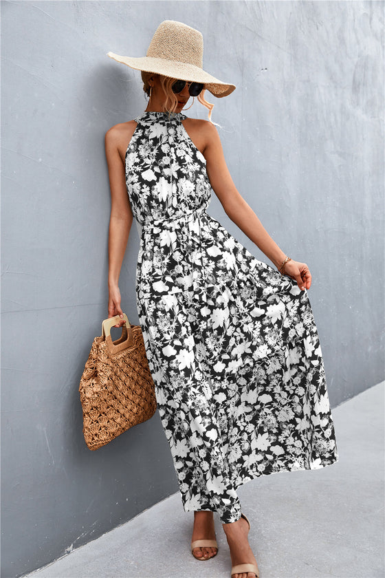 Black sleeveless printed maxi dress with a flattering tie waist—sophisticated and versatile summer look for day or evening wear.