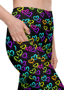  Close-up of Black Rainbow Melting Hearts High-Waisted Compression Leggings showing the side pocket design. Stylish, functional, and perfect for workouts or casual wear.