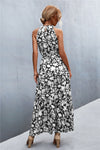 Back view of black sleeveless printed maxi dress with elegant drape—casual yet polished look for travel and daytime plans.