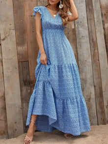  Elegant blue maxi dress with floral print, deep V-neckline, and fluttery ruffled sleeves—styled in a graceful full front view.