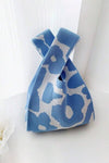 Side view of the blue flower-knitted handbag, showing off the colorful and detailed floral design in a deep blue tone.