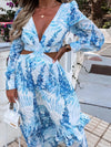 Full front view of the blue maxi dress with floral print, dramatic ruffled detailing, and flared hemline designed to flow with every step—ideal for summer vacations or beach events.