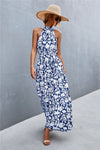 Front image of blue printed sleeveless maxi dress with tie waist and long flowing hem—cool, casual, and perfect for summer events.
