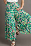 Front-facing view of the wide-leg green pants with vibrant mixed patterns, designed for movement and effortless daywear.

