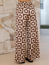  Back of the brown printed pants shown in a flatlay format, highlighting pocket details and comfortable elastic waistband.