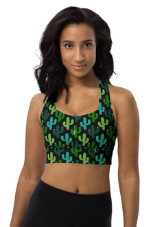  Woman wearing the Cactus Bloom Black High Impact Racerback Sports Bra. Featuring a bold cactus print and a playful lizard design, offering high support, breathable mesh lining, and a secure racerback fit for workouts.