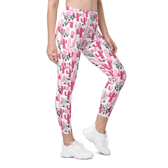 Front view of model wearing Cactus Cowgirl pink cactus print high waisted leggings. Stylish compression leggings for women with side pockets.