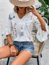  Front view of a relaxed-fit white blouse featuring soft floral prints and half sleeves, ideal for workwear or daytime wear.