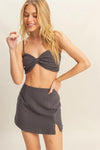 Full front view showing the flattering fit and bold, stylish silhouette of the charcoal bra top and mini skirt set.

