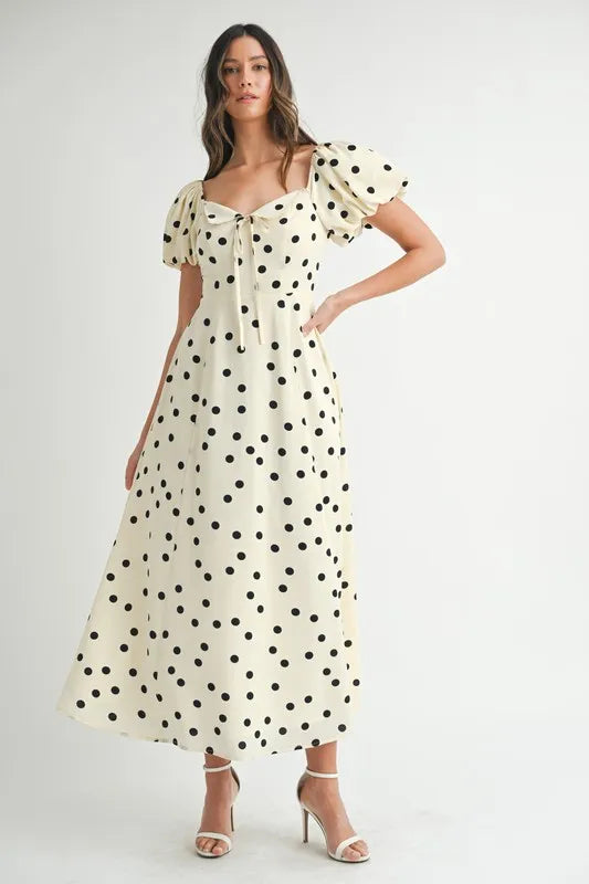 Full front view of cream midi dress with puff sleeves and all-over dot print, offering a refined and feminine look.