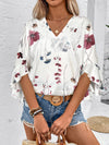  Front view of a crisp, clean white blouse with elegant prints and tailored half sleeves, styled with modern accessories.