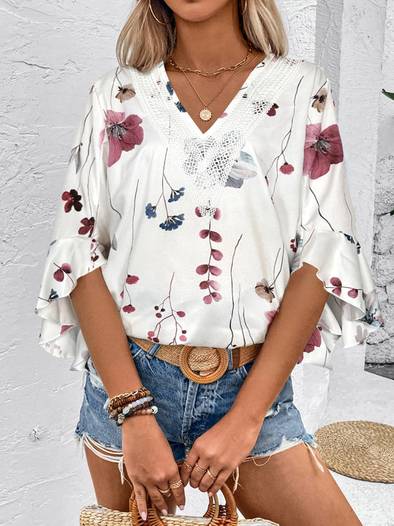  Front view of a crisp, clean white blouse with elegant prints and tailored half sleeves, styled with modern accessories.