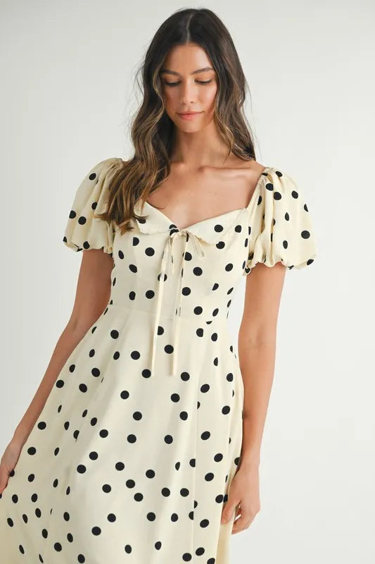 Closeup front view of cream puff sleeve midi dress showcasing the delicate neckline and small dotted pattern.