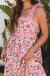  Detailed close front view of the pink floral square neck dress highlighting the pocket stitching, floral fabric, and square neckline construction.

