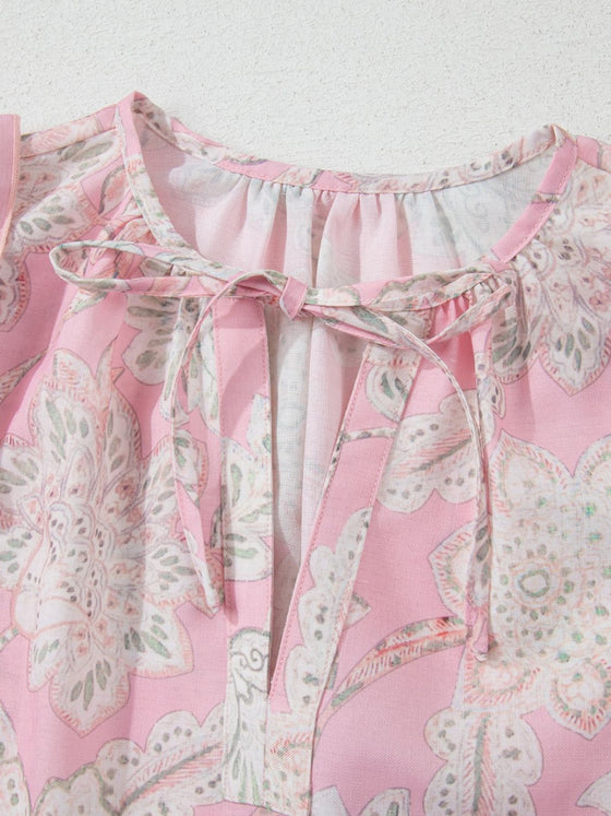 Detailed neckline close-up of the pink blouse, showing floral print and gentle gathers along the rounded neck.