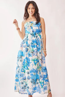  Model wearing the cobalt blue cut-out maxi dress, walking forward to showcase the dynamic movement of the flowy fabric and the vibrant printed design.

