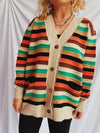 Close-up of a Contrast Stripes Button-Up Long Sleeve Cardigan with vibrant horizontal stripes in red, green, and beige tones, styled casually with black pants.