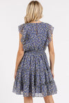  A back view of the Dark Navy Whisper Floral Ruffle Mini Dress, displaying the graceful cut and subtle flow that adds a touch of sophistication.


