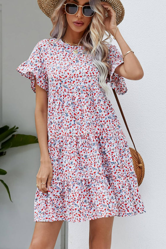 Model wearing the Ditsy Floral Flounce Sleeve Tiered Dress, styled with casual accessories for a chic look.