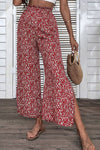 Model wearing ditsy floral wide-leg pants with paperbag waist and side slits, perfect for summer casual outfits.