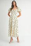 Polka dot cream midi dress featuring puff sleeves captured from the front to showcase its flattering, timeless style.