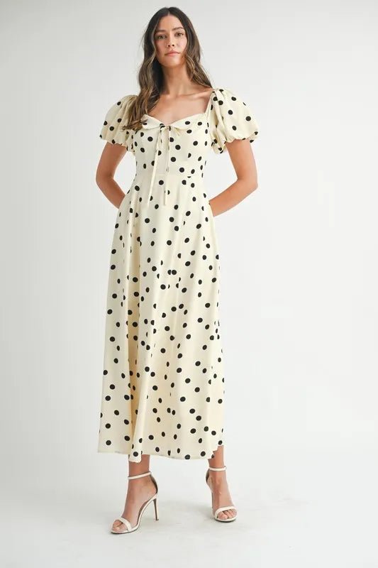 Polka dot cream midi dress featuring puff sleeves captured from the front to showcase its flattering, timeless style.