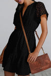 Side view of the Eyelet Notched Mini Dress showing the flouncy mini hem and semi-sheer fabric.