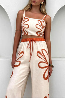  Elegant front view of the cream floral cami and wide-leg pants set, styled with a romantic square neckline and a flowy trouser silhouette ideal for sunny days.