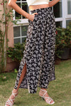 Model wearing floral wide-leg cropped pants with paperbag waist and ankle slits, ideal for casual and vacation outfits.