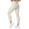 Model walking in white spring floral print leggings. High waist compression leggings for women with pockets, perfect for gym, yoga, or brunch days.
