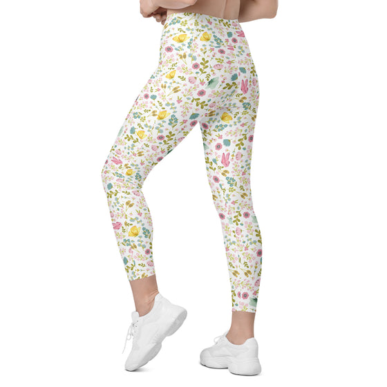 Model walking in white spring floral print leggings. High waist compression leggings for women with pockets, perfect for gym, yoga, or brunch days.