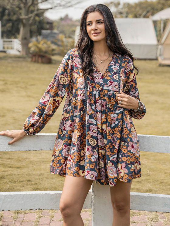 Model wearing dark floral the Floral Ruched V-Neck Long Sleeve Dress styled for a bohemian outdoor look.