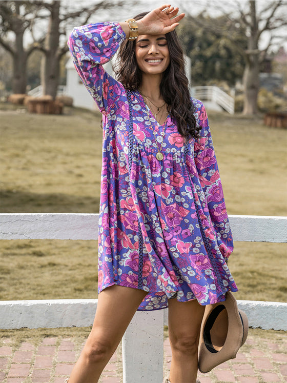 Model purple wearing the Floral Ruched V-Neck Long Sleeve Dress styled for a bohemian outdoor look.