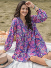 Woman wearing a purple floral ruched V-neck dress with long sleeves, perfect for casual chic style.