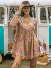 Woman wearing a floral ruched V-neck long sleeve dress with a boho style, perfect for casual outings and vacations.
