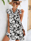 Woman wearing a black and white floral dress with butterfly sleeves and a tie neckline, perfect for casual summer outings.

