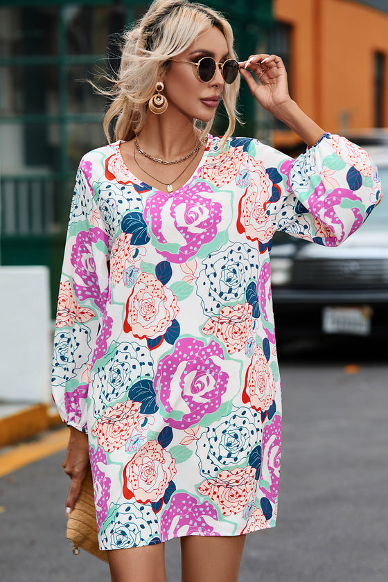 Woman wearing a colorful floral V-neck long sleeve dress, ideal for casual and stylish occasions.