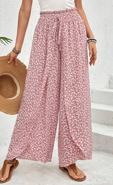  Woman wearing floral print wide-leg palazzo pants with a drawstring waist.
