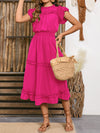 Woman styled in the Frill Round Neck Midi Dress with a woven bag and sandals, perfect for garden parties.